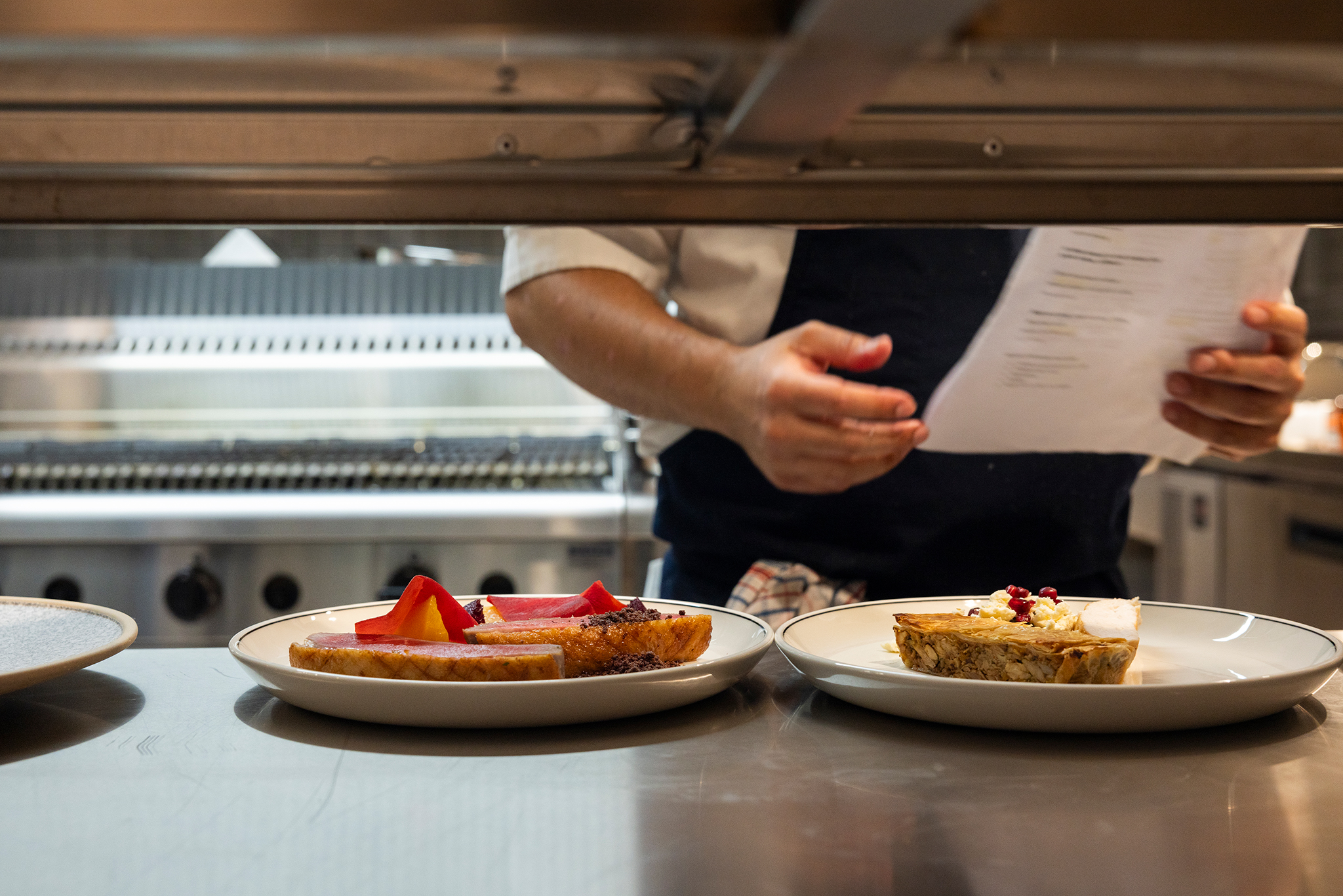 Chef preparing plates of food in a restaurant kitchen